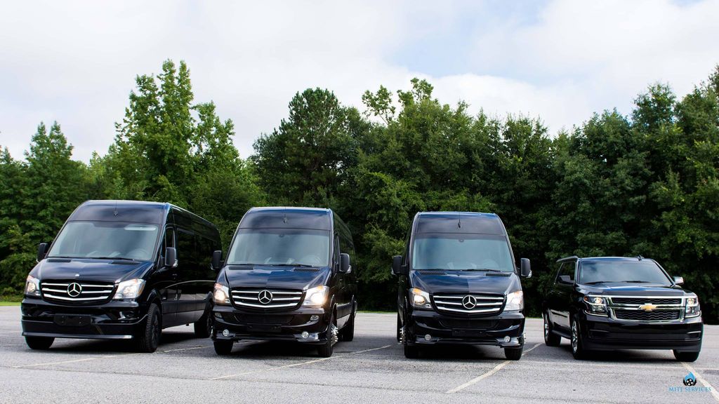 The Quality Concierge Transportation fleet of black Sprinter vans and an SUV